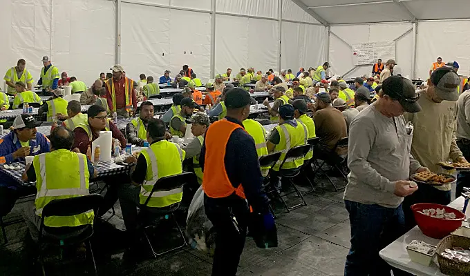 A large tent with tables set up for workers at lunch