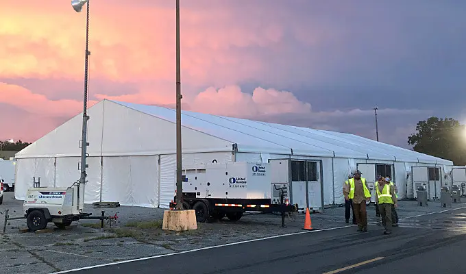 Large tent with electrical equipment and men in visibility vests
