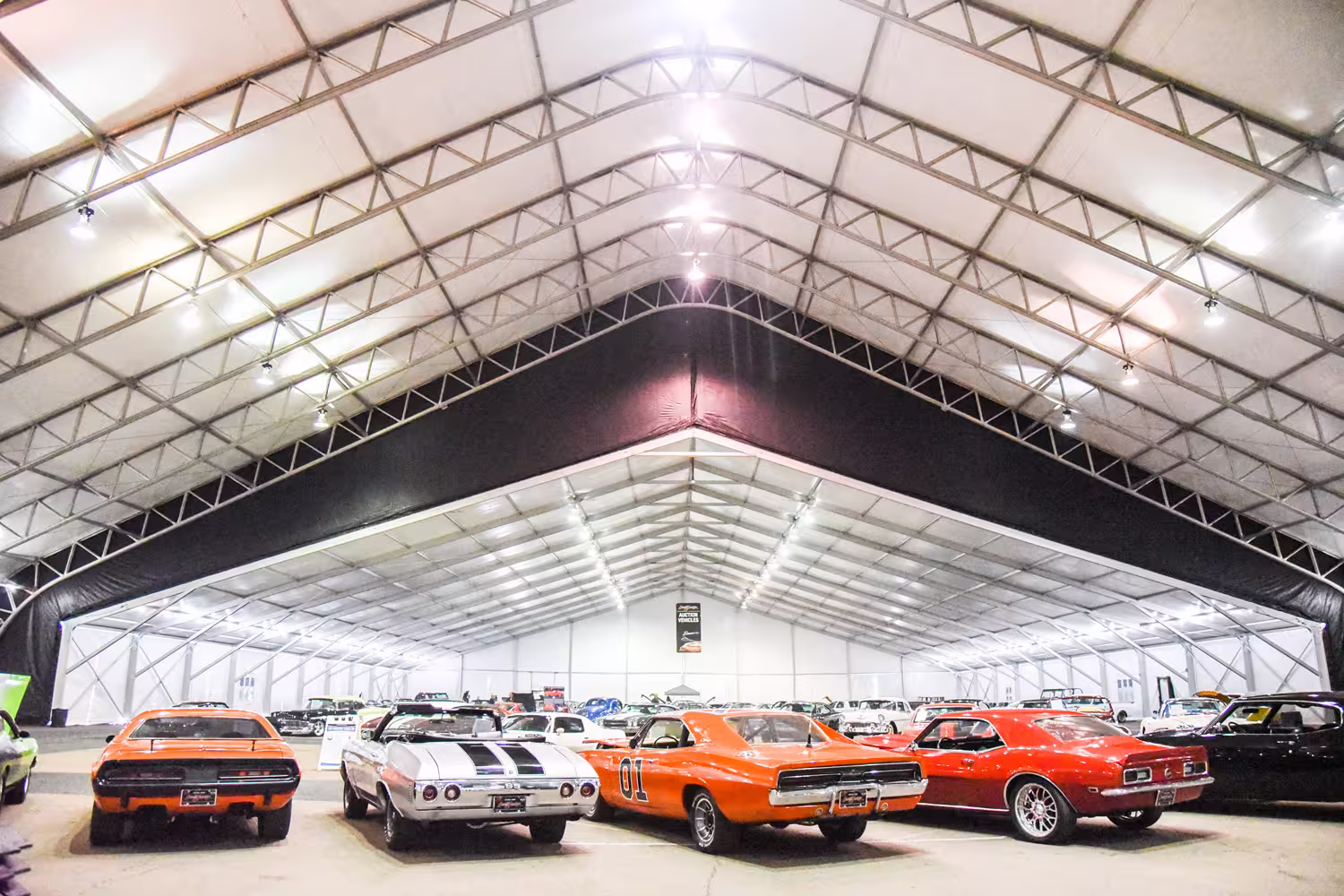 Well lit structure tent with sports cars inside