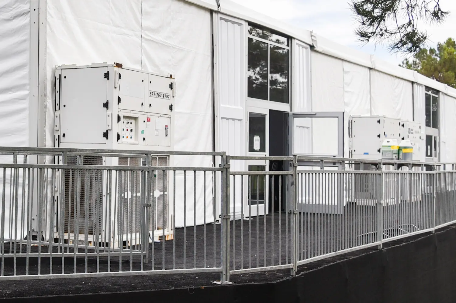 HVACs and generators on the back of a tent