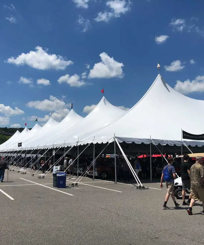 People walking past a tension pole tent