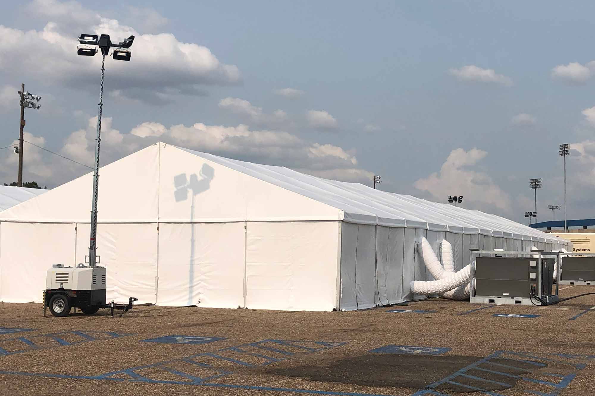 White tent with floodlight in front