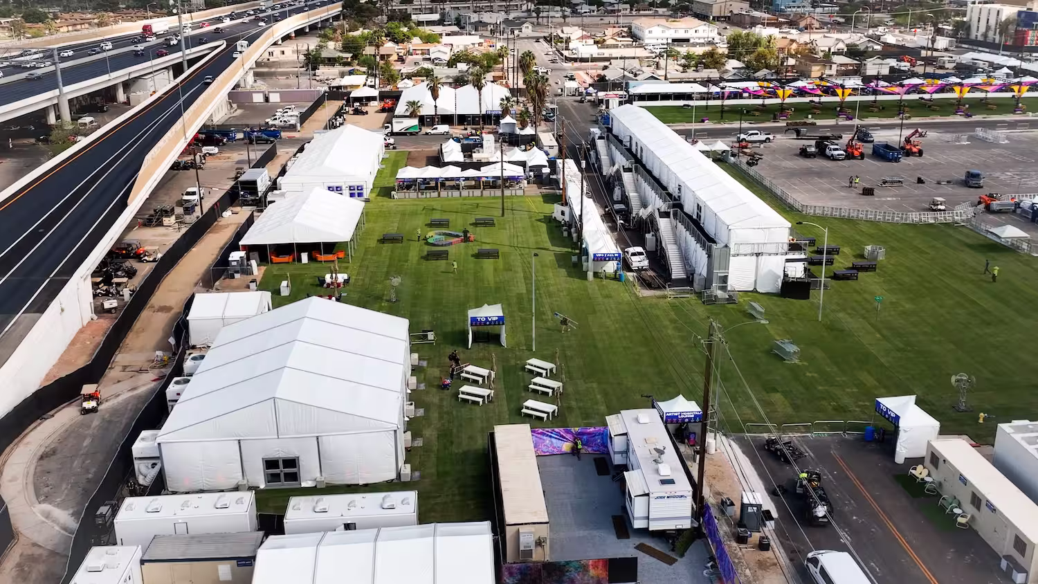 Aerial shot of several large and small tents surrounding a field