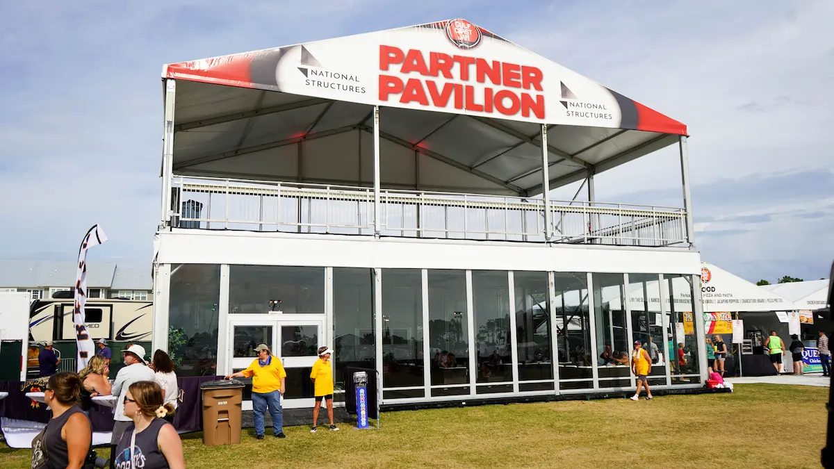 Multi Story tent reading "partner pavilion" on banner on top of tent