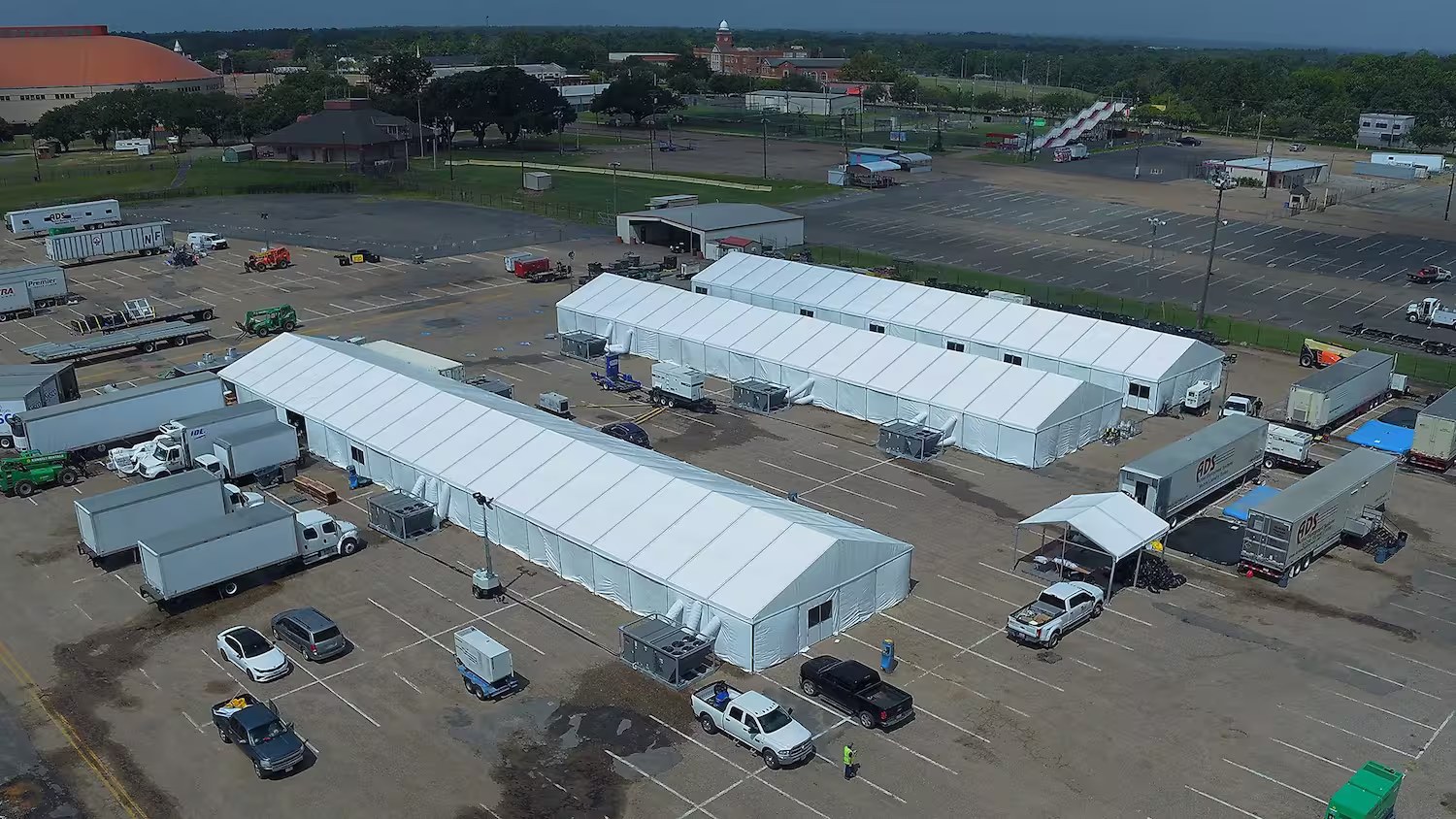 Aerial shot of 3 long tents with air conditioners and other equipment connected