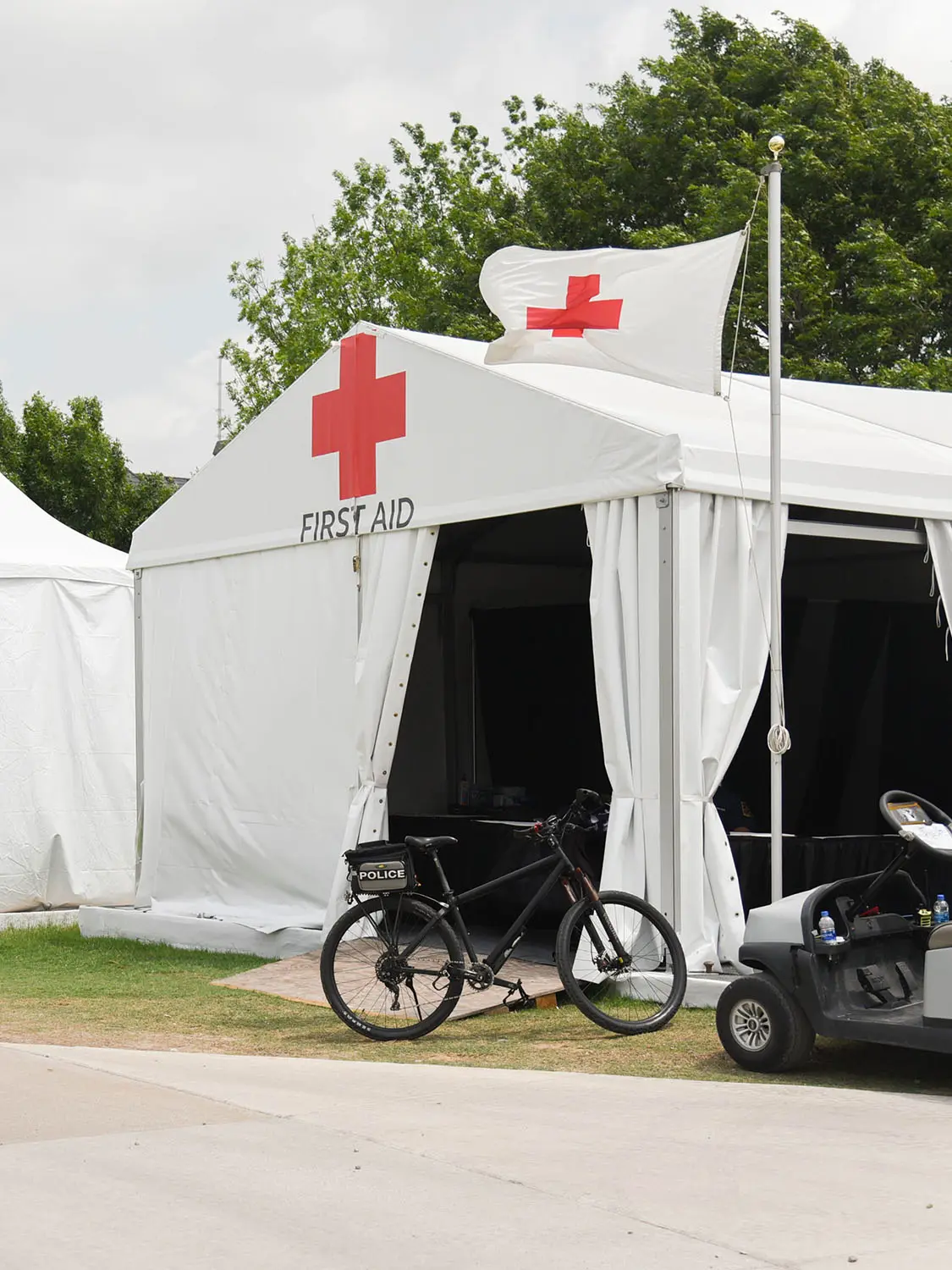 White tent with red cross on it with "first aid" below