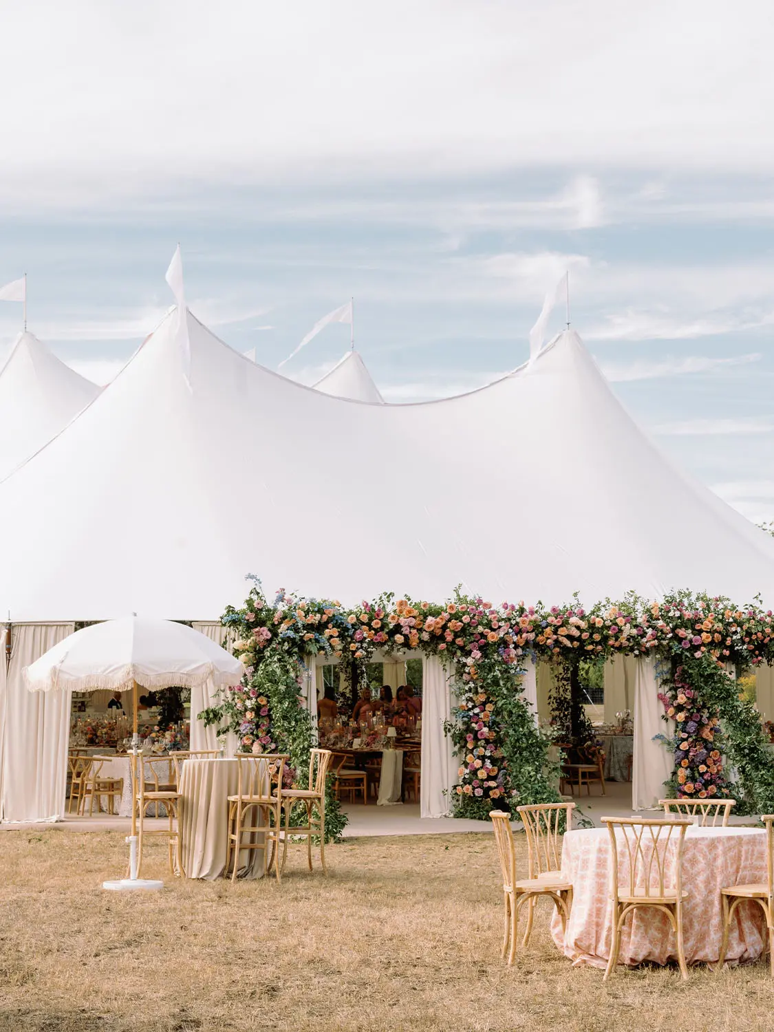 Large High Peak white cloth tent set up at wedding with decorations 