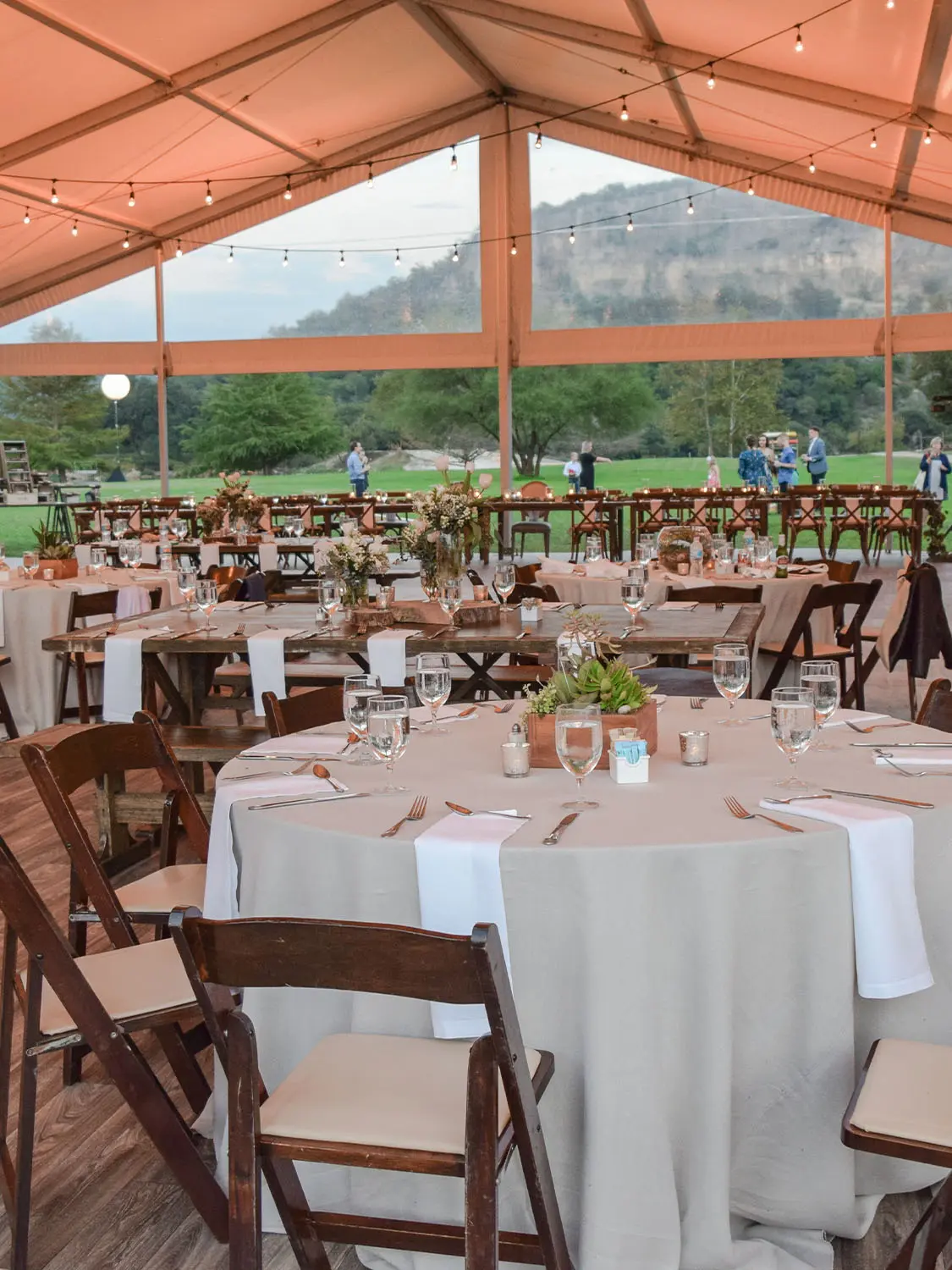 Tables and Chairs set up for event under large Tent Structure