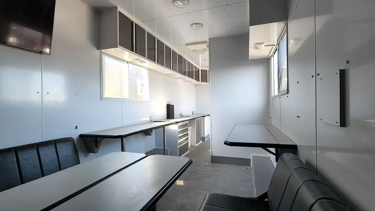 Inside of a Mobile Trailer Setup, white benches and seating inside trailer
