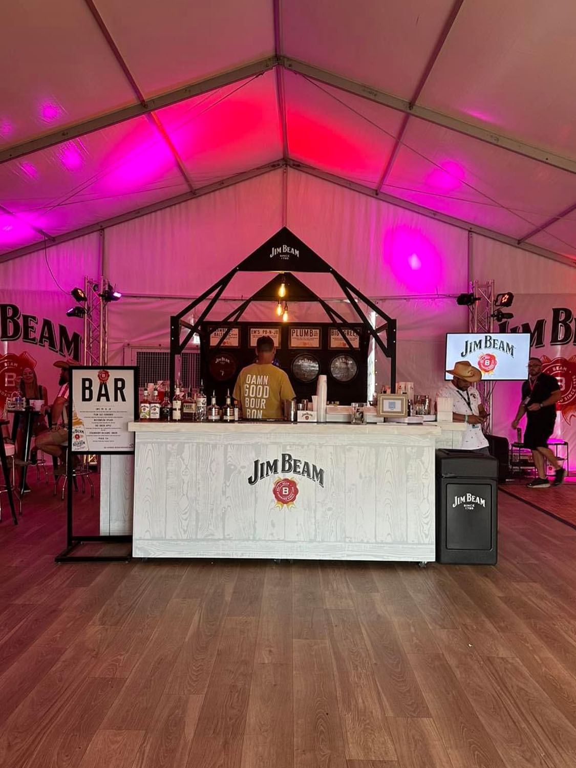 Jim Beam logo on white bar on top of hardwood floor