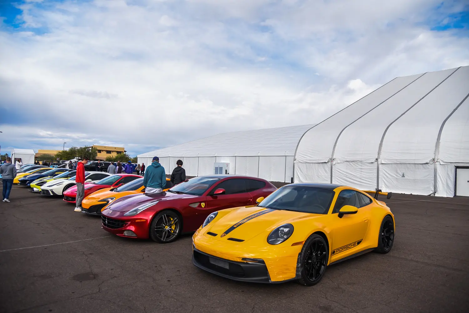Car expo.  Two luxury cars in front of white tents